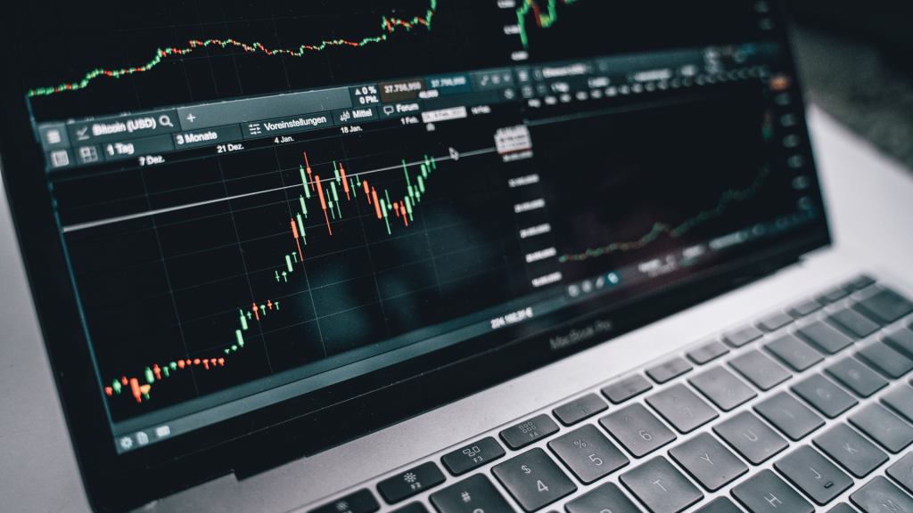 A laptop displaying a trading graph