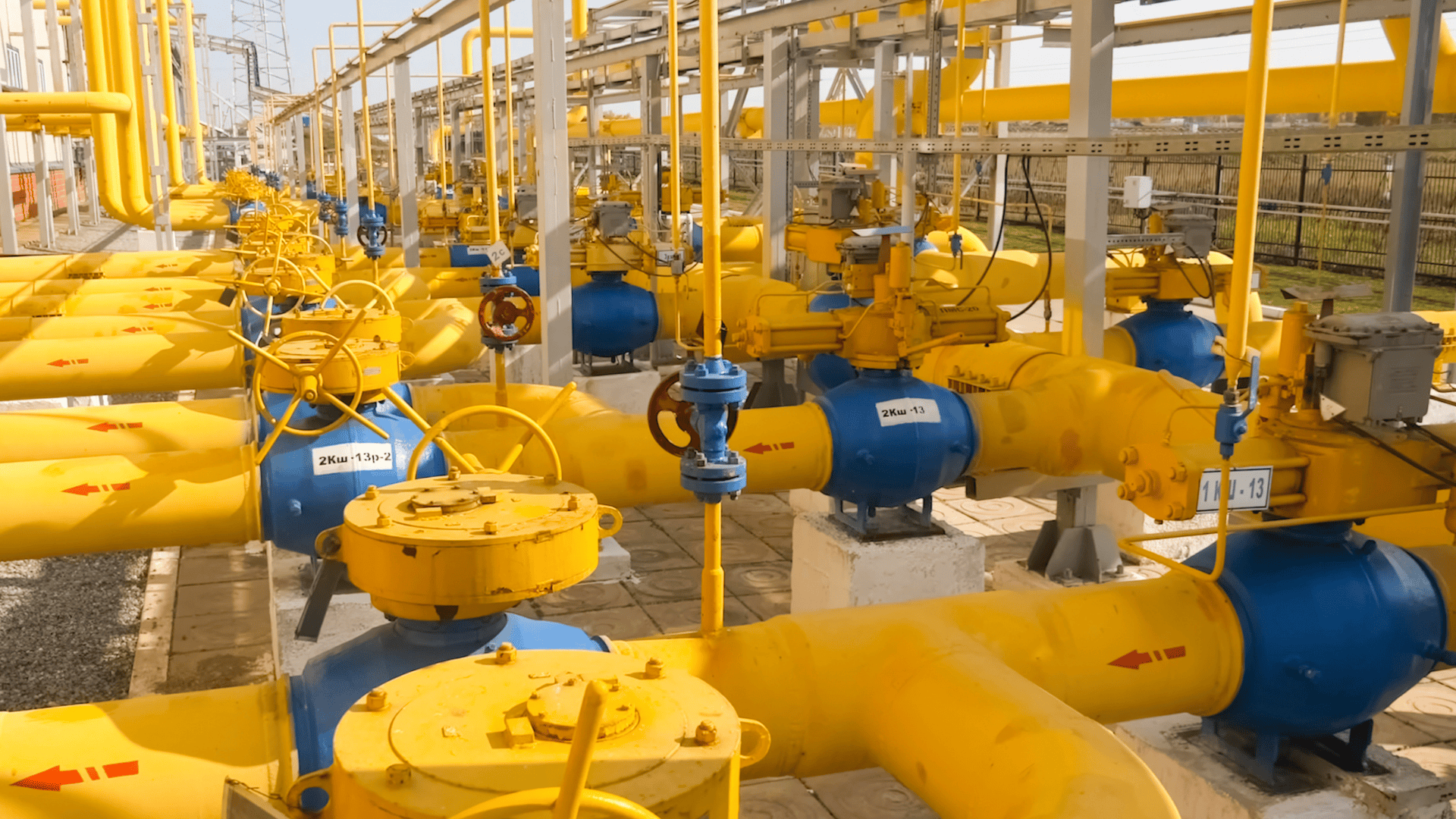 Industrial natural gas pipeline system with yellow pipes and control valves at a processing facility