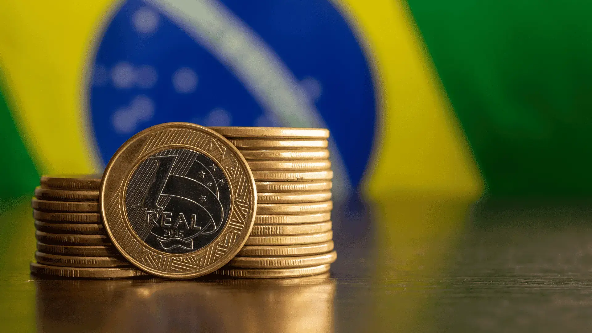 Brazilian real coins stacked with the Brazil flag in the background, representing Brazil’s financial markets and currency