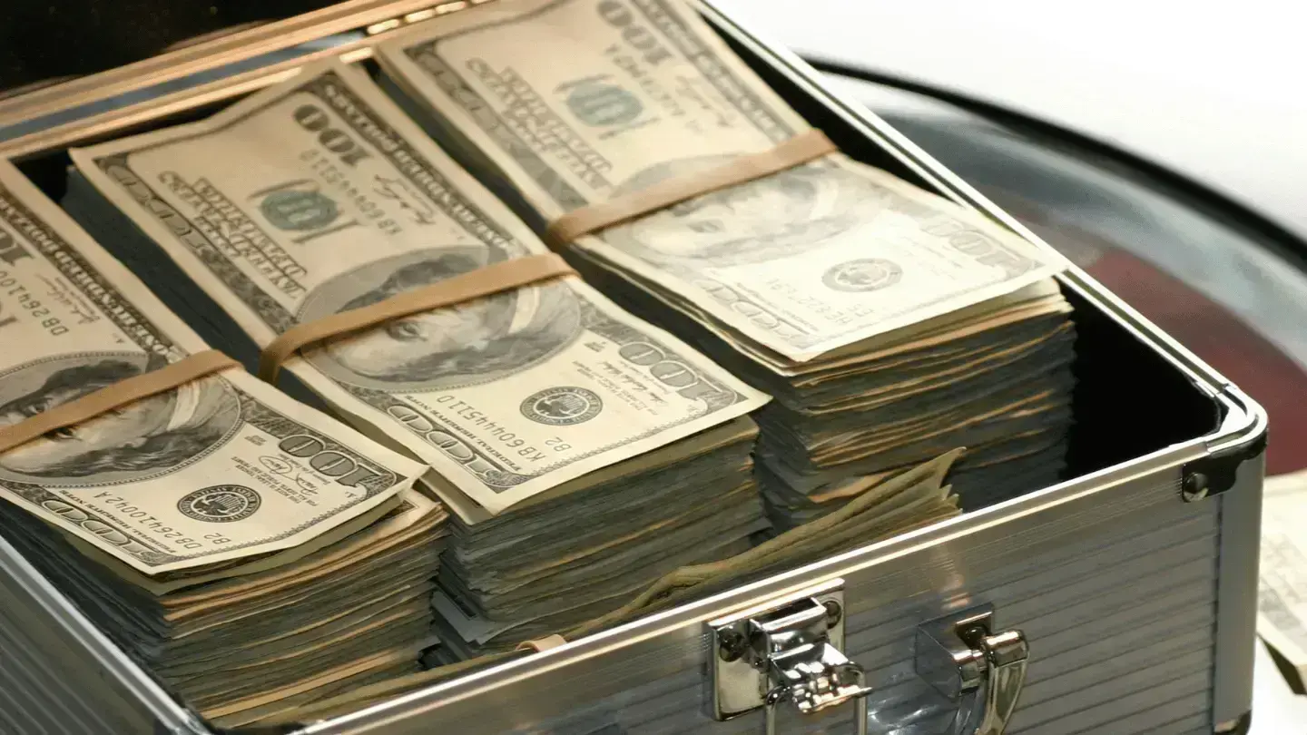 Stacks of US dollar banknotes bundled and stored in a metal briefcase